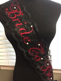 the back of a black dress with red lettering on it