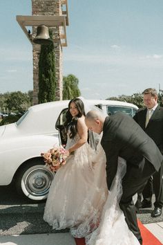 the bride and groom are getting ready to get into their wedding car at the ceremony