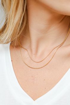 We're ready to swear our love to the Brianna Gold Layered Chain Necklace! This trendy necklace features two layers of gold chains. Style the Brianna Necklace with any outfit to instantly upgrade your look! Gold Plated Layered Lobster Clasp with Extender Layer 1 | Length 8" Layer 2 | Length 7.5" Extender | Length 2" Gold Double Chain Snake Necklace For Everyday, Gold Double Chain Snake Necklace In Minimalist Style, Trendy Gold Snake Chain Necklace With Delicate Chain, Gold Minimalist Double Chain Snake Necklace, Gold Charm Necklaces For Layering, Double Snake Chain Necklace For Layering, Double Chain Snake Necklace For Layering, Snake Chain Necklace With Double Chain For Layering, Gold Double Chain Snake Necklace For Layering