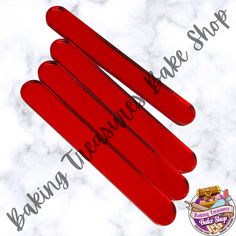 three red popsicle sticks sitting on top of a marble counter