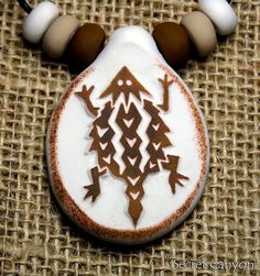 a white and brown necklace with an intricate design on it