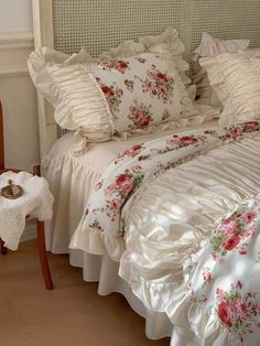 a white bed topped with lots of pillows next to a night stand and nightstands