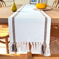 a table with two pears on it and a white table cloth draped over the top