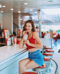 a woman sitting at a bar with a drink in her hand