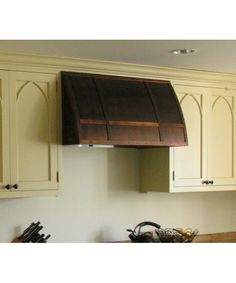 a kitchen with white cabinets and an oven hood