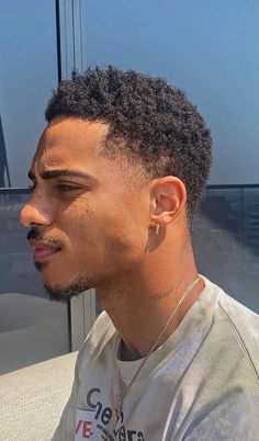 a close up of a person with an afro haircut and wearing a t - shirt