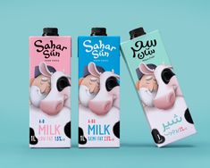 two milk cartons are shown side by side on a blue and pink background, one has a cow's face painted on it