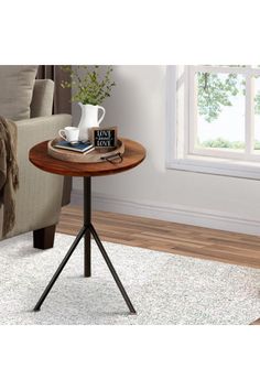 a small table with a book and coffee cup on it in front of a couch