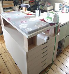 a sewing machine sitting on top of a wooden table next to a counter with drawers