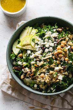 a bowl filled with greens, nuts and cheese