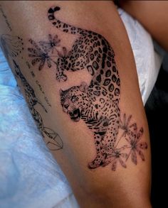 a tattoo on the arm of a woman with a cheetah and flower design