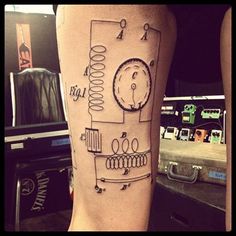 a person with a tattoo on their leg that has a drawing of a mechanical device