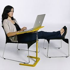 a woman sitting in a chair using a laptop computer