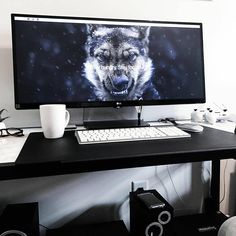 a desktop computer with a wolf on the screen and speakers next to it, sitting on a desk