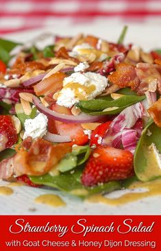 a salad with strawberries, spinach and bacon on it