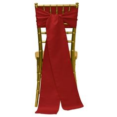 a red chair sash tied to the back of a wooden folding chair with gold frame