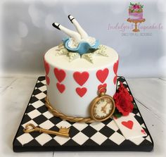 a cake decorated with an umbrella and clock on a checkerboard tablecloth plate