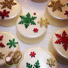 six decorated christmas cookies sitting on top of a white tablecloth covered table with red, green and gold snowflakes