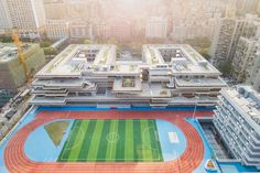 an aerial view of a soccer field in the middle of a city with high rise buildings