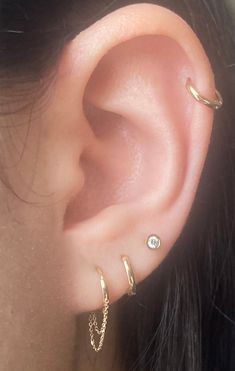 a close up of a person's ear with three different piercings