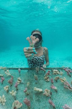 a woman in a leopard print swimsuit is holding up her hand while standing under the water