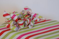 a pile of colorful candy canes sitting on top of a striped table cloth covered in pink, green and white stripes