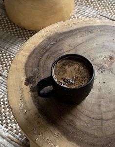 a cup of coffee sitting on top of a wooden table