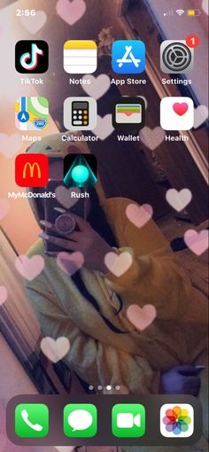 an iphone screen with many icons on it and hearts coming out of the phone's display