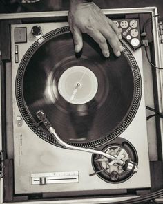 a person is holding onto a record player's turntable with their hand on it