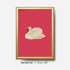 a white swan floating on top of a pink background in a gold framed art print