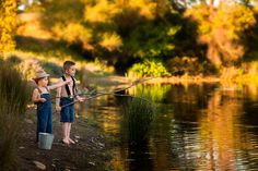 two young boys fishing on the river bank