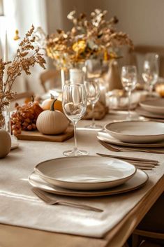 the table is set with white plates and place settings