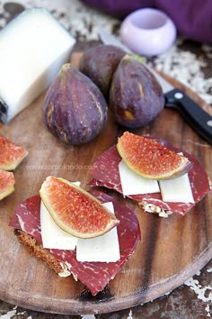 figs, cheese and bread on a wooden cutting board