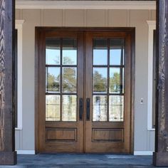 two wooden doors with glass on the front of a house