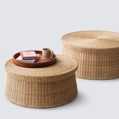 two round wicker tables with trays and cups on each one, sitting side by side