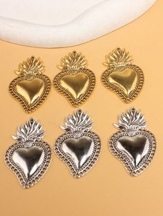 six heart shaped charms sitting on top of a table