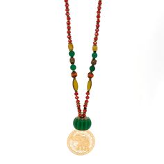 This Mystic Bohemian Elephant Necklace is a unique and colorful piece of jewelry that combines bohemian style with a touch of mysticism. The necklace features a combination of different beads including clear crystal beads, green jade beads, and colorful African beads. It also includes gold-colored hematite stone beads, gold-colored hematite Buddha beads, and gold-colored hematite stone heart beads. The necklace is highlighted by a handmade glass green color floral large bead, and it is finished Festive Spiritual Beaded Necklaces With Colorful Beads, Festive Spiritual Beaded Necklace With Colorful Beads, Green Artisan Necklace For Festive Occasion, Traditional Green Long Necklace Beads, Long Traditional Green Necklace, Festive Green Artisan Necklace, Bohemian Red Beads, Gems, And Cabochons, Handmade Green Beaded Necklaces For Festivals, Green Faceted Beads Necklaces For Festivals