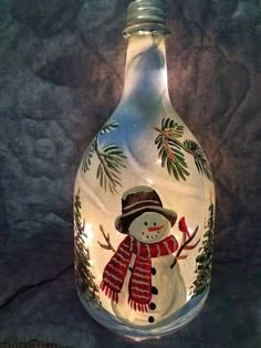 a glass bottle with a snowman painted on it