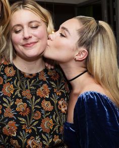 three women are kissing each other while one woman is holding her face close to the camera