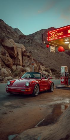 a red sports car parked in front of a gas station with a neon sign above it