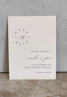 a white wedding card with the word save the date printed on it in black ink