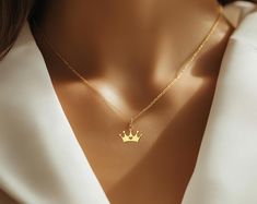 ☆ Queen Crown Necklace - Gold Plated Royal Charm Jewelry for Women elegant gold crown necklace is perfect for anyone who wants to feel like royalty. Featuring a beautiful crown design with a heart in the center, this gold plated pendant is both stylish and regal. Whether you're gifting it to a queen in your life or treating yourself to something special, this crown necklace adds a touch of royalty to any outfit. At Opiona Jewelry, we craft all our pieces with dedication and care. This handmade 925 sterling silver necklace is a special treat for yourself or a thoughtful gift for a loved one. We offer customization options, including personal names or inscriptions--feel free to message us for more details. ☆ The standard necklace length is 16" for adults and 12" for kids. ☆ Materials: 925 St Elegant Gold Jewelry With Crown Design, Elegant Gold Crown Design Jewelry, Dainty Jewelry With Crown Design For Gift, Dainty Jewelry With Crown Design As Gift, Elegant Crown Pendant Jewelry, Gold Necklaces With Crown Design For Gifts, Elegant Crown Design Necklace For Gift, Elegant Crown Design Necklace For Wedding, Crown Necklace