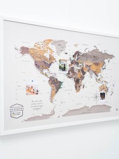 a white framed world map hanging on the wall