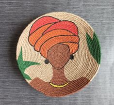 a woven basket with an african woman's head painted on the front and sides