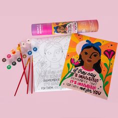 two coloring books, markers and pencils on a pink background next to each other