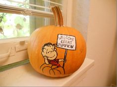 a pumpkin decorated with a cartoon character holding a sign that says welcome to great pumpkin