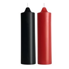 two black and red candles sitting next to each other