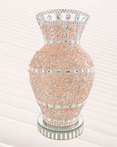 a pink vase sitting on top of a glass stand with lots of crystals in it