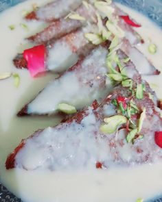 three pieces of cake with white frosting and red flowers on top in a blue plate