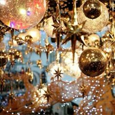 christmas decorations hanging from the ceiling in front of a store window with lights and stars